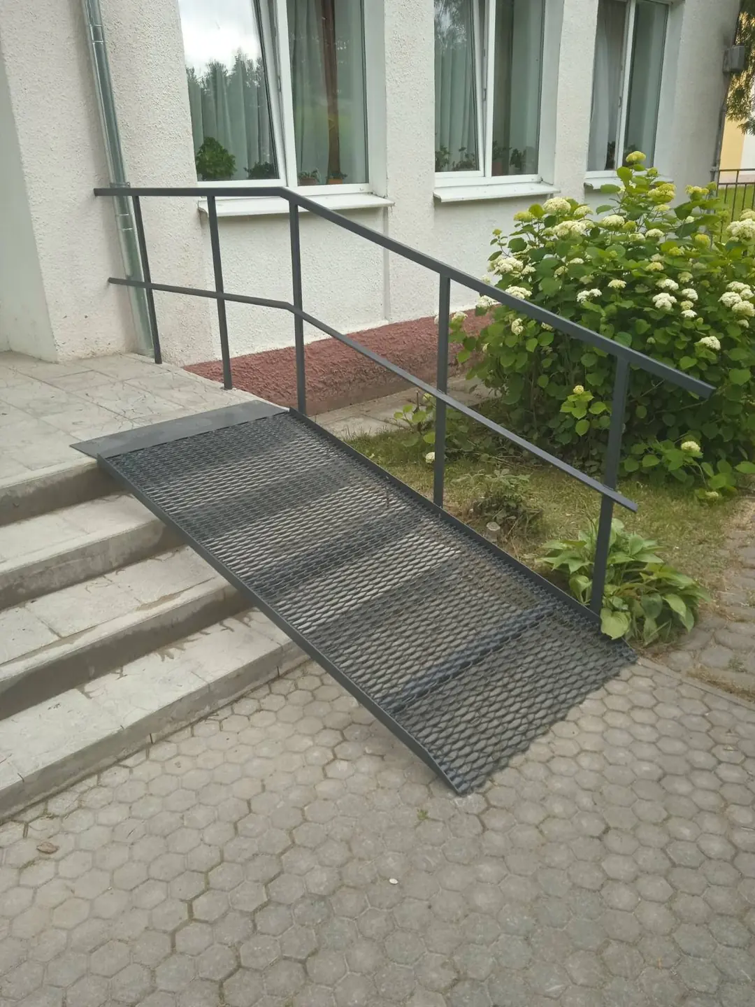 Металлический пандус с ограждением у входа в здание